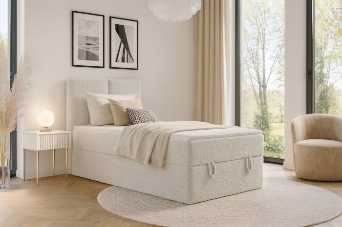 Gemütliches Einzel-Boxspringbett in hellem Bouclé-Design in einem modern eingerichteten Schlafzimmer.