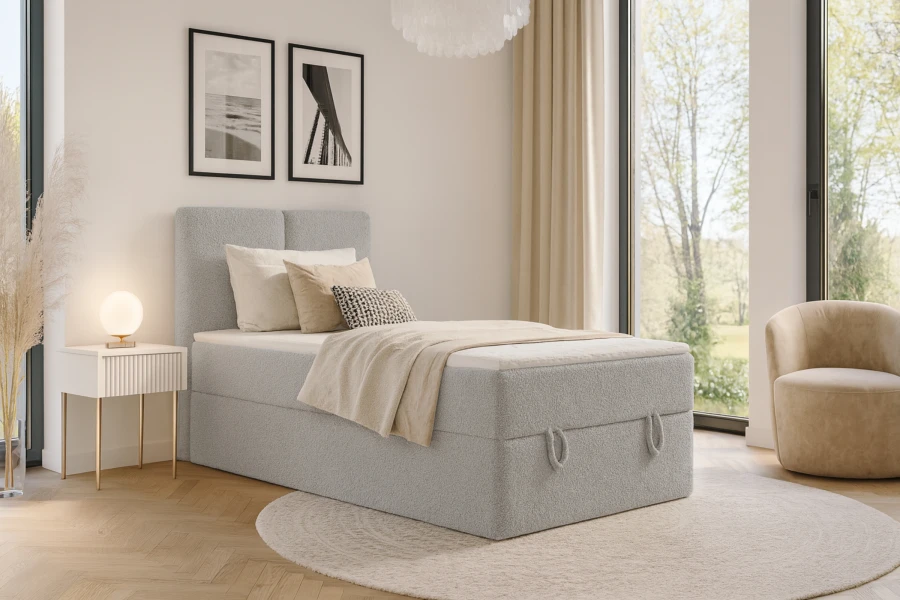 Hellgraues Boxspringbett dekoriert in einem hellen, modernen Schlafzimmer mit Nachttisch und Teppich.