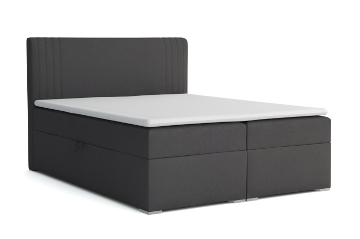 Dunkelgraues Boxspringbett mit gestepptem Kopfteil und weißem Topper, isoliert auf weiß.