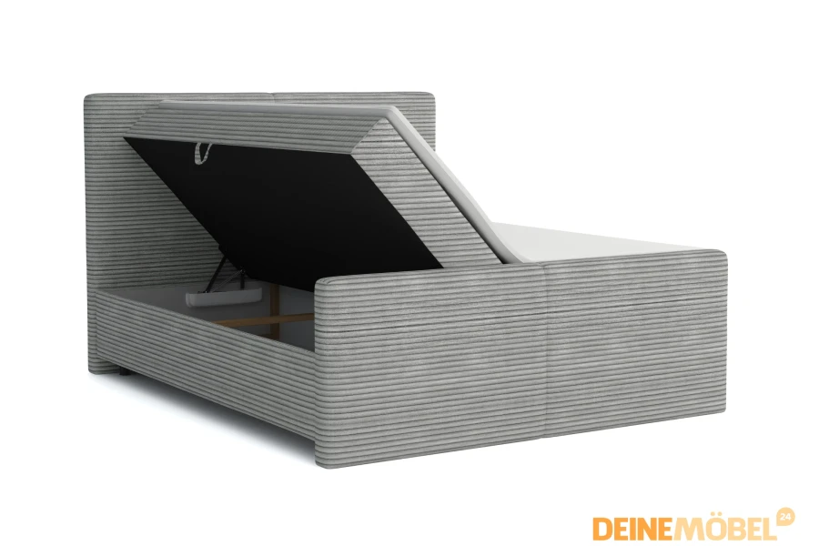 Graues Boxspringbett aus Cord mit geöffnetem Bettkasten für Stauraum.
