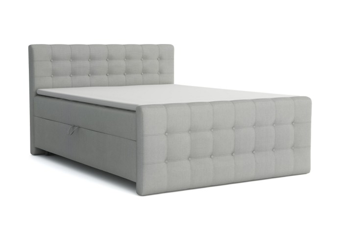 Seitliche Ansicht eines grauen Boxspringbetts mit gestepptem Kopfteil vor weißem Hintergrund.