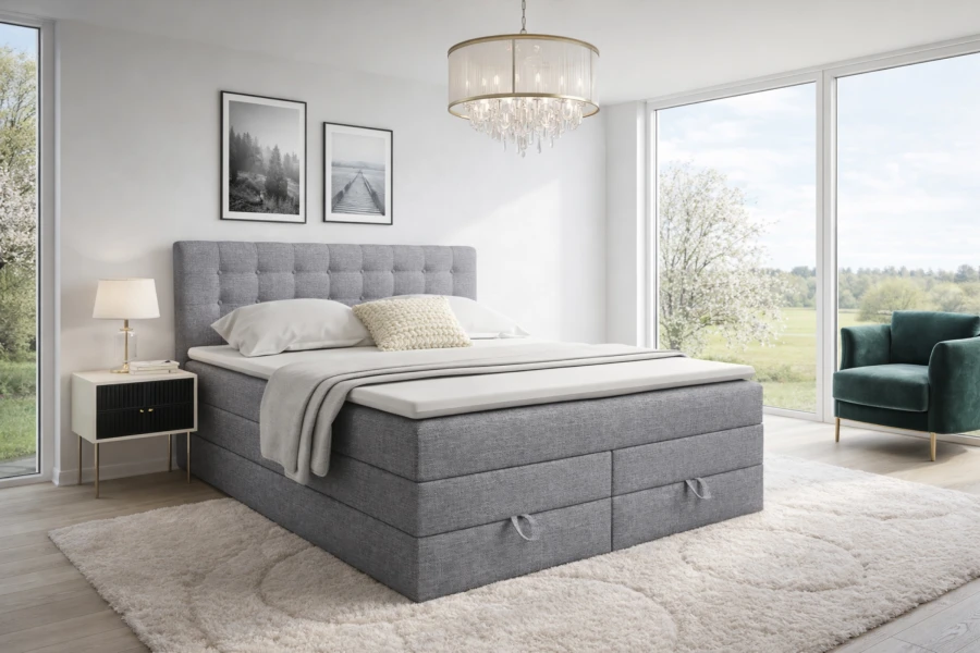 Stilvoll eingerichtetes Schlafzimmer mit dem hellgrauen Boxspringbett Verno, Teppich und gemütlichem Sessel.