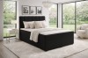Black upholstered bed in boxspring style for a luxurious sleeping ambience.