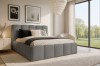 Stilvolles graues Polsterbett in hellem Schlafzimmer mit großen Fenstern und idyllischem Ausblick.
