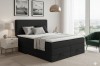 Modernes Schlafzimmer-Ambiente mit schwarzem Boxspringbett und Dekoration.