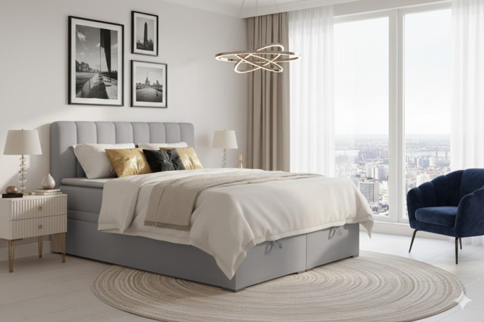 Modernes Boxspringbett DAVID in Hellgrau mit gestepptem Kopfteil in einer hellen Schlafzimmerumgebung.
