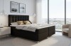 Anthrazitfarbenes Boxspringbett in modernem Schlafzimmer mit Aussicht und hellem Interieur.
