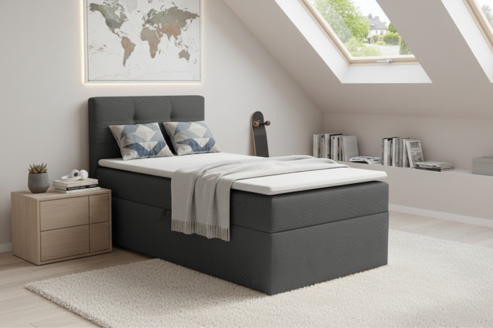 Gemütliches Boxspringbett in Anthrazit in einem hell eingerichteten Schlafzimmer im Dachgeschoss.
