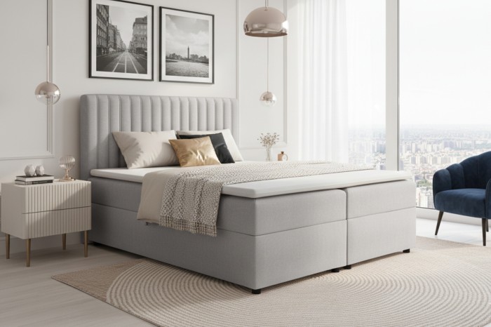 Modernes hellgraues Boxspringbett in einem stilvollen Schlafzimmer mit Stadtblick.