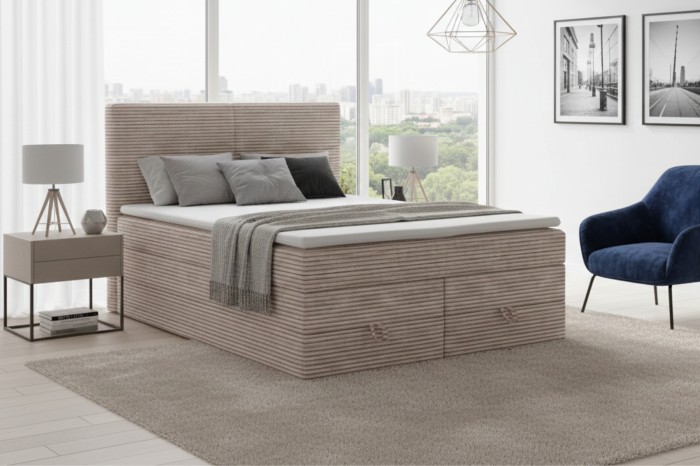 Hell eingerichtetes Schlafzimmer mit gemütlichem Cord-Boxspringbett und Fensterfront.