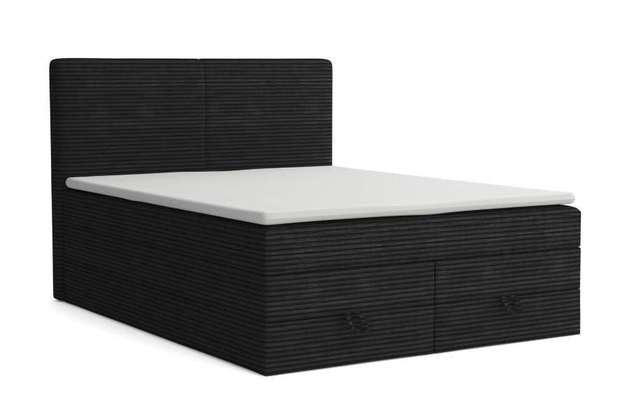 Schwarzes Boxspringbett aus Cord-Stoff mit weißem Topper auf weißem Hintergrund.