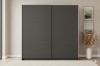 Modern wardrobe in dark grey with sliding doors in a bright bedroom.