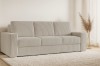 Beiges Cordsofa in stilvollem Wohnzimmer-Ambiente mit Teppich und Pampasgras.