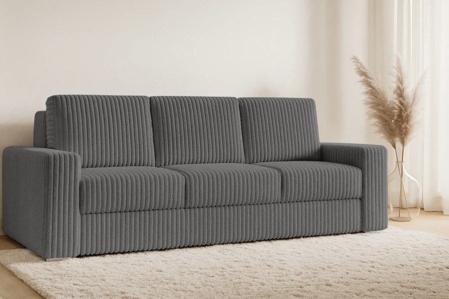 Dunkelgraues Cordsofa im gemütlichen Wohnzimmer-Ambiente mit hellem Teppich.