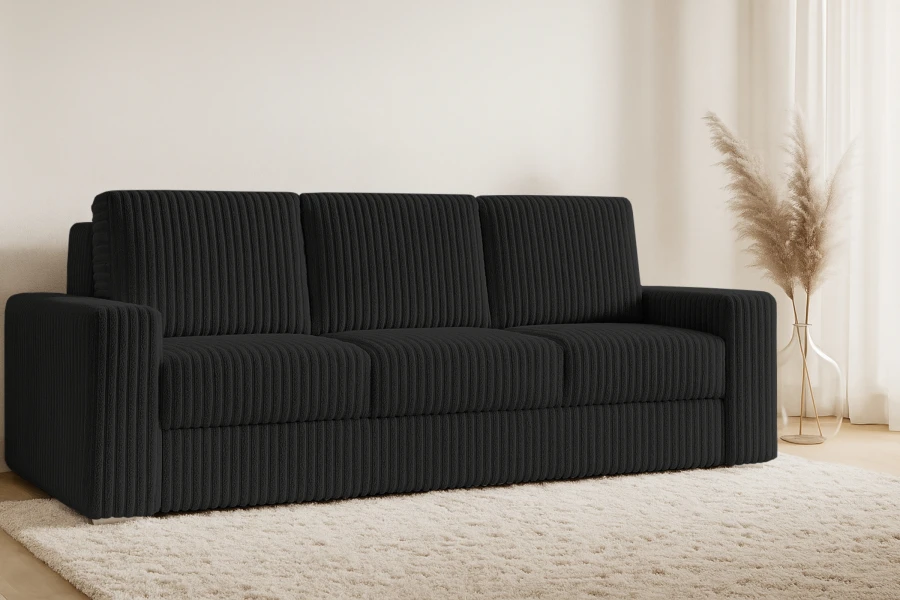 Schwarzes Cord-Sofa in stilvollem Wohnzimmer mit hellem Teppich.