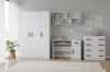 Modernes Kinderzimmer-Möbelset in Weiß mit lila Griffen, Schrank und Schreibtisch.