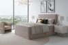Beiges Boxspringbett mit Rippenstruktur in modernem Schlafzimmer-Ambiente.