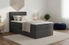 Modernes Boxspringbett in Anthrazit mit Cord-Kopfteil und weißem Topper.