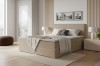 Beige farbenes Boxspringbett in modernem Schlafzimmer mit Holzpaneelen.