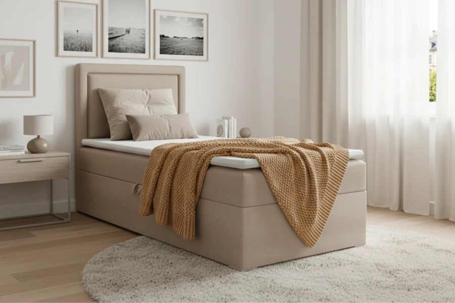 Beiges Boxspringbett mit Stauraum, weißem Topper und gelber Decke im modernen Schlafzimmer.