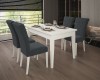Eetgroep met witte eettafel en vier donkergrijze gestoffeerde stoelen in modern interieur.