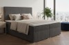 Graues Boxspringbett aus Cord-Stoff in modernem Schlafzimmer mit City-Panorama.