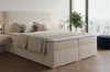 Sandfarbenes Boxspringbett mit Cord-Bezug, stilvolle Einrichtung mit Blick auf New York.