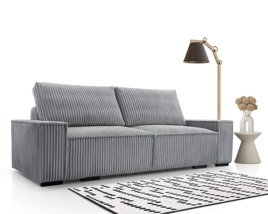 Modernes graues Cordsofa im Wohnzimmer mit Stehlampe und Teppich.