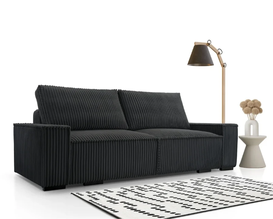 Dunkelgraues Cordsofa in modernem Wohnambiente mit schwarzer Lampe.