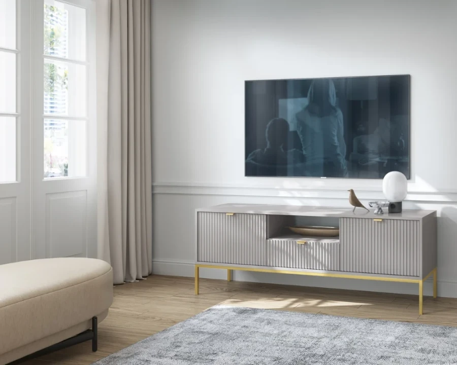Eingerichtetes Wohnzimmer mit grauem TV-Unterschrank unter einem Fernseher.
