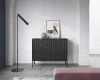 Stilvolles Wohnzimmer mit schwarzem Sideboard, Stehlampe und Deko.