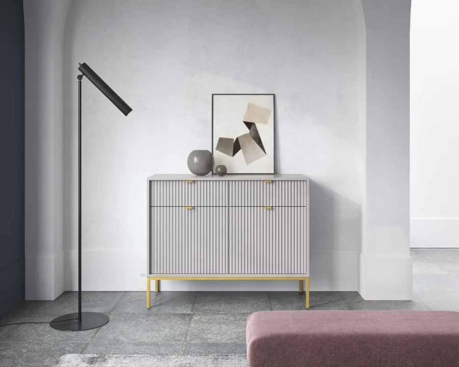Elegantes graues Sideboard mit Rillenfront neben einer modernen schwarzen Stehlampe.