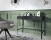Elegante Raumszene mit schwarzem Konsolentisch vor einer grünen Wand mit Zierleisten.