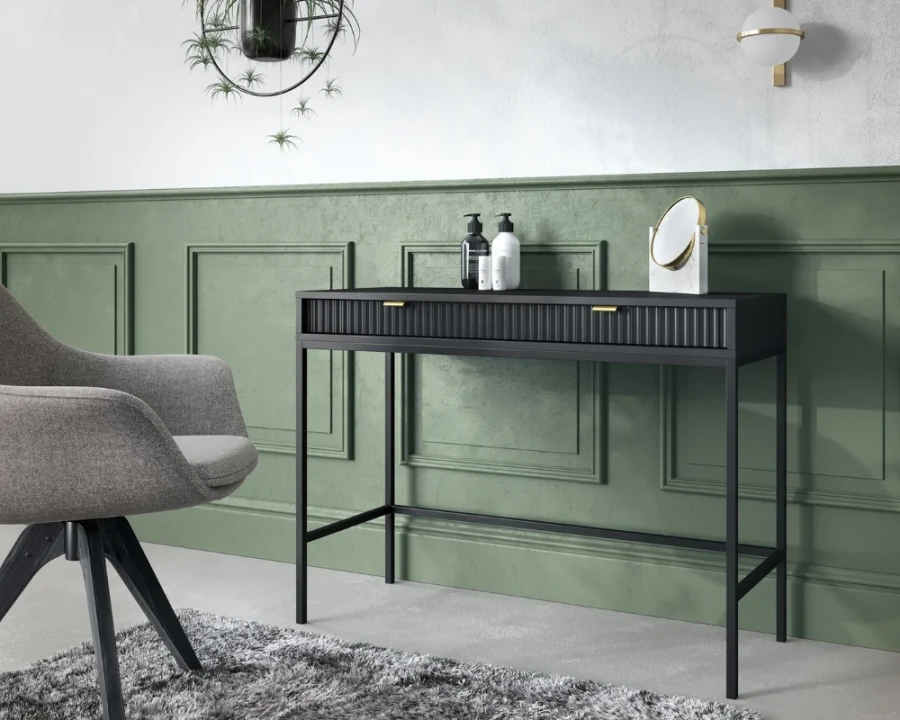 Elegante Raumszene mit schwarzem Konsolentisch vor einer grünen Wand mit Zierleisten.