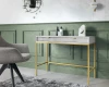 Moderner weißer Schminktisch mit Goldgestell vor einer grünen Wand in einem stilvollen Interieur.