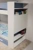 Weißes Etagenbett mit integriertem Bücherregal und Stauraum.