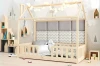 Gemütlich dekoriertes Hausbett mit Lichterkette und gepolsterten Wandpaneelen im Kinderzimmer.