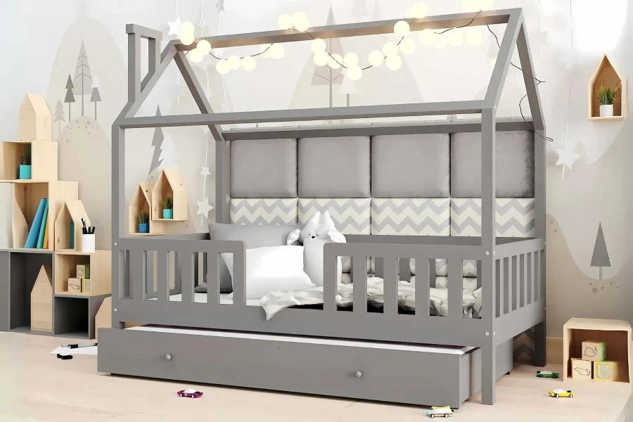 Graues Hausbett mit Ausziehbett und Lichterkette im Kinderzimmer.