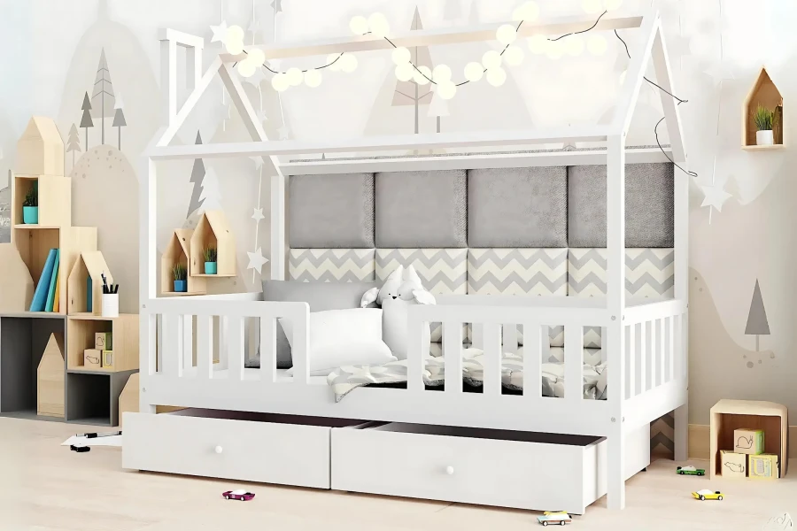 Dekoriertes Kinderbett in Hausform mit Lichterkette und grauen Wandpolstern.
