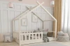 Weißes Hausbett für Kinder mit Rausfallschutz und dekorativen Kissen im Kinderzimmer.