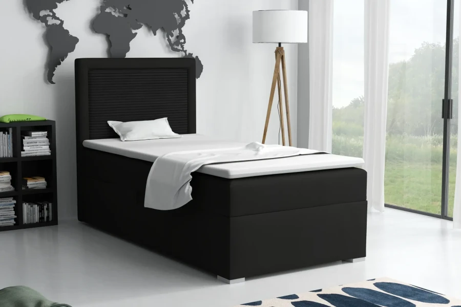 Modernes Schlafzimmer mit schwarzem Boxspringbett, Stehlampe und Weltkarten-Wanddeko.