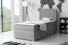 Graues Boxspringbett in hellem Zimmer mit Weltkarten-Wanddeko und modernem Einrichtungsstil.