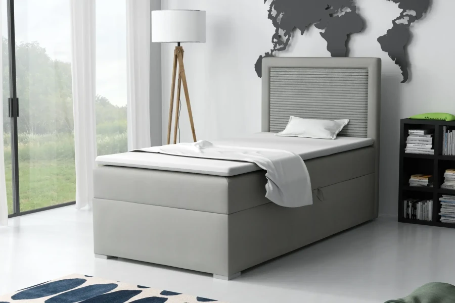 Graues Boxspringbett in hellem Zimmer mit Weltkarten-Wanddeko und modernem Einrichtungsstil.