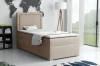 Beiges Boxspringbett im hellen Schlafzimmer-Ambiente mit Stehlampe und Bücherregal.