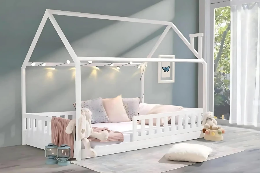 Gemütliches Kinderhausbett mit Lichterkette, dekorativen Kissen und Stofftieren.