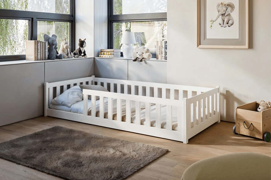 Modernes weißes Bodenbett aus Holz in einem hellen Kinderzimmer mit gemütlicher Dekoration.
