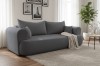 Dunkelgraues Polstersofa in modernem Wohnzimmer mit flauschigem Teppich und Zimmerpflanze.