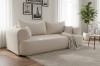 Cremefarbenes Sofa in elegantem Wohnzimmer mit hellem Teppich und Blumen.