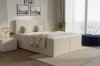 Modern boxspringbed in beige met corduroy-bekleding in een lichte slaapkamer met uitzicht op de stad.