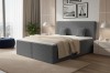 Elegant box spring bed in dark grey with corduroy look and cushions in a modern bedroom.
